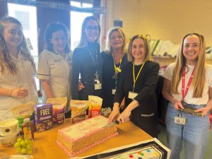 Oonagh cuts cake with Clinical Research Radiographers