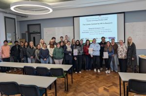 students standing at front of lecture theatre with guest lecturers