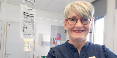 Photo of patient Ann McBrien in a hospital setting getting cancer medication through a drip.