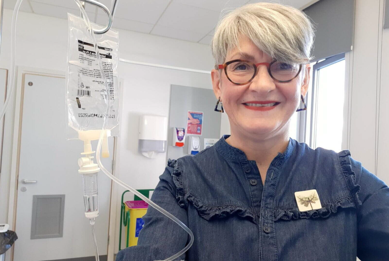 Photo of patient Ann McBrien in a hospital setting getting cancer medication through a drip.